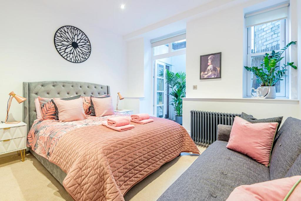 een slaapkamer met een bed en een bank bij ARCORE Premium Rental Shaftesbury Avenue in Londen