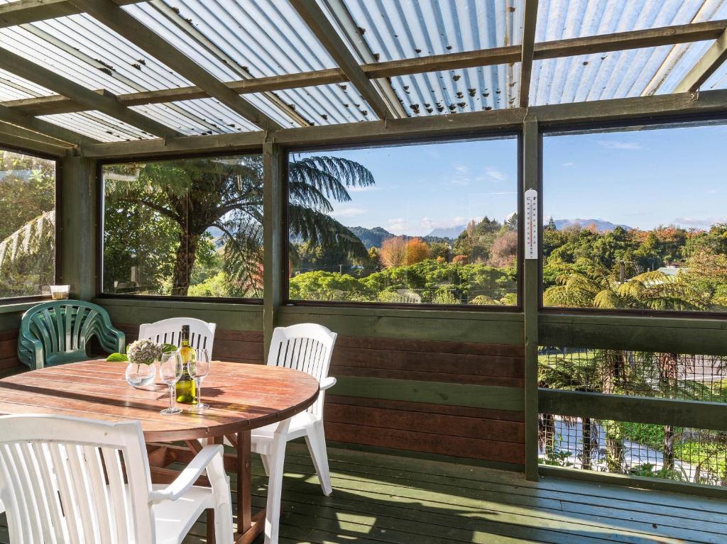 - une table et des chaises sur une terrasse couverte avec vue dans l'établissement Family Fun at The Lake - Lake Tarawera Home, à Lake Tarawera