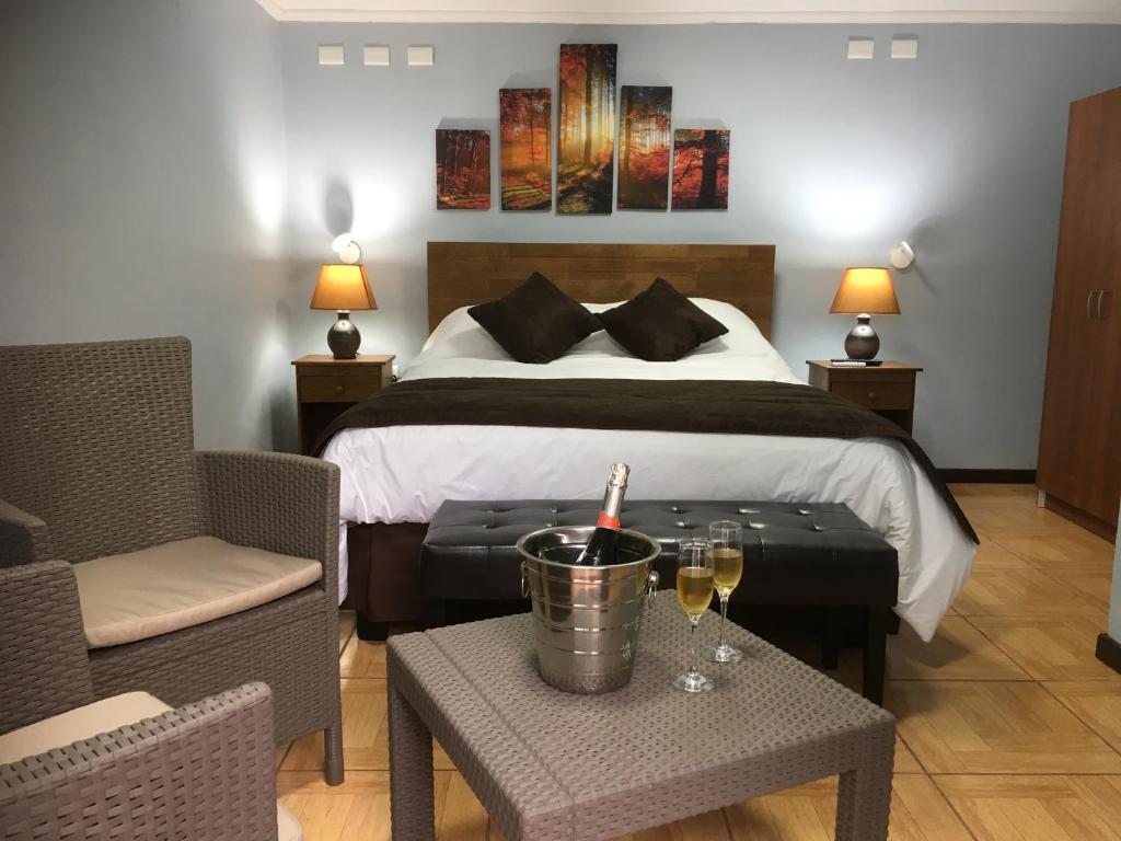 PelluhueにあるAbundia Hotel Boutique de Turismoのベッド、テーブル(ワイングラス付)が備わる客室です。