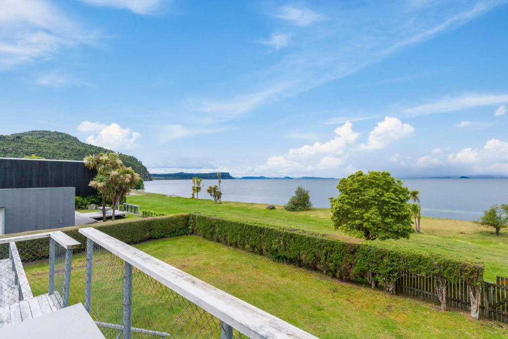 vistas al agua desde el balcón de una casa en Lakefront Lodge - Kuratau Holiday Home en Kuratau