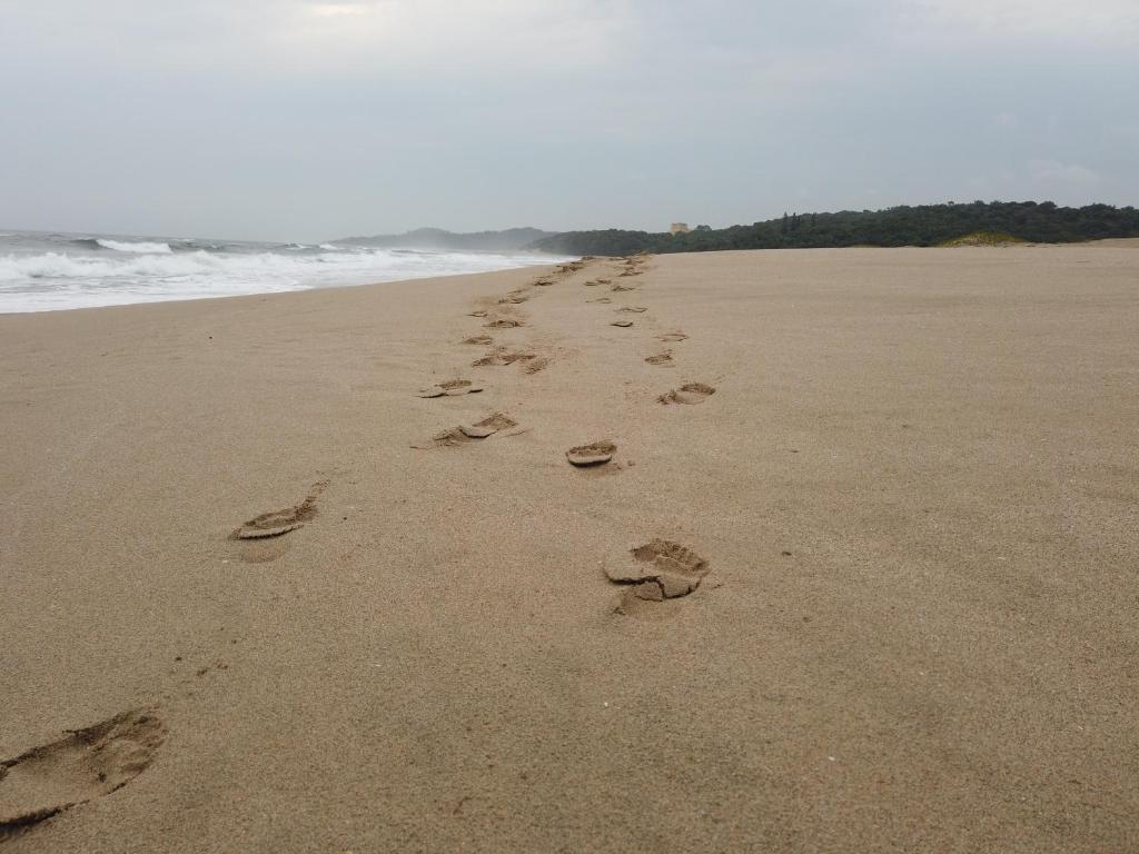 a pair of footprints in the sand on a beach at Caribbean Estates: Barbados No. 12 in Port Edward