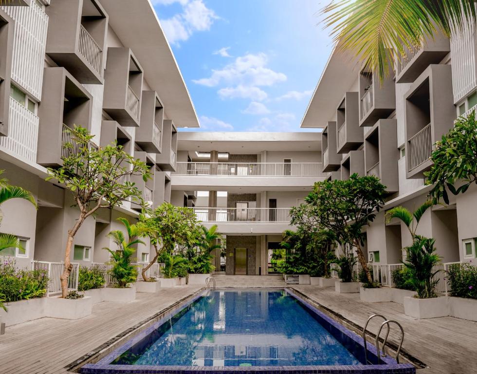 uma imagem do pátio de um edifício com piscina em The Rooms Apartment Bali by ARM Hospitality em Denpasar