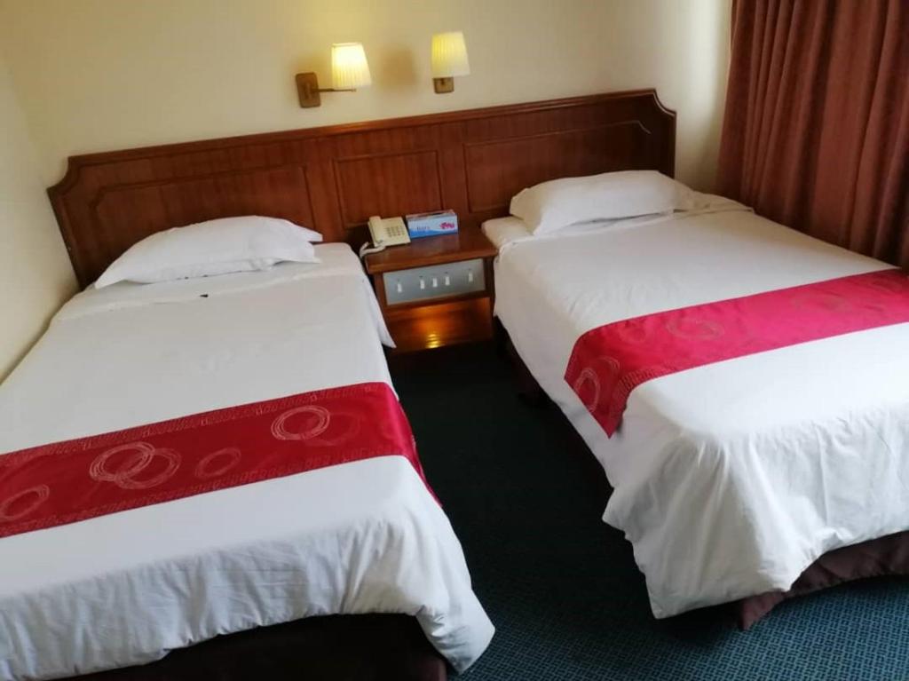 Postel nebo postele na pokoji v ubytování Pacific Orient Hotel ( 凯富大酒店 )