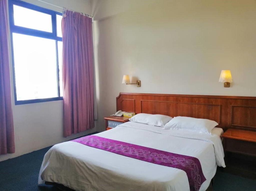Postel nebo postele na pokoji v ubytování Pacific Orient Hotel ( 凯富大酒店 )
