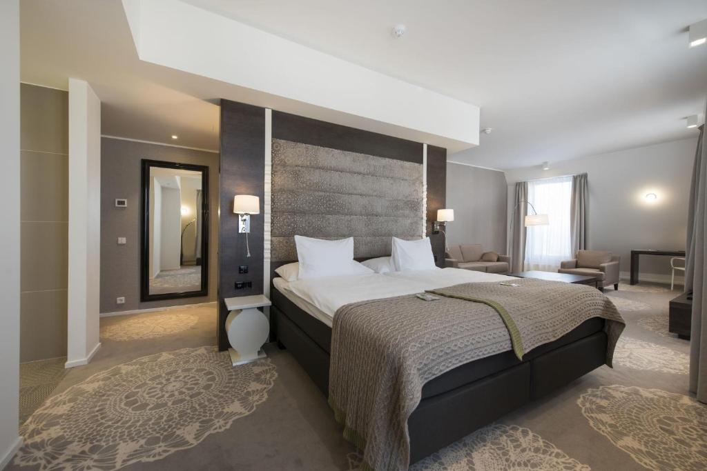 
a bedroom with a large bed and a large window at Lydia Hotel in Tartu
