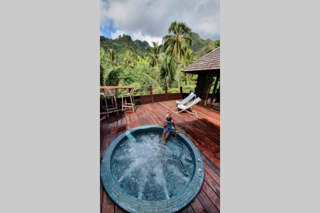 a view of a deck with a pool and a house at Luxurious Tropical Moorea Villa in Papetoai