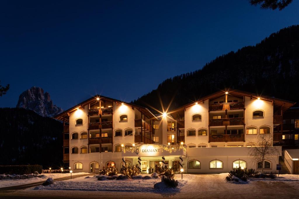 um hotel na neve à noite em Diamant Spa Resort em Santa Cristina in Val Gardena