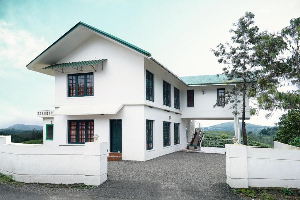 a white house with a large driveway at Vagamon Tea County in Vagamon