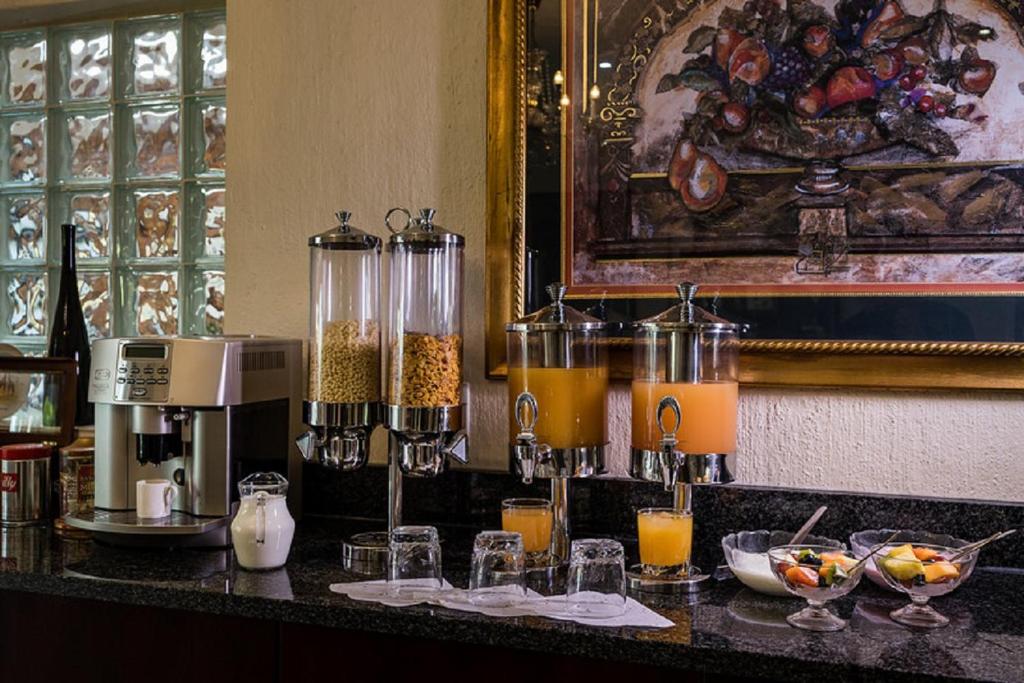 a counter with glasses of orange juice and a coffee maker at Gallo Manor Executive Bed & Breakfast in Johannesburg