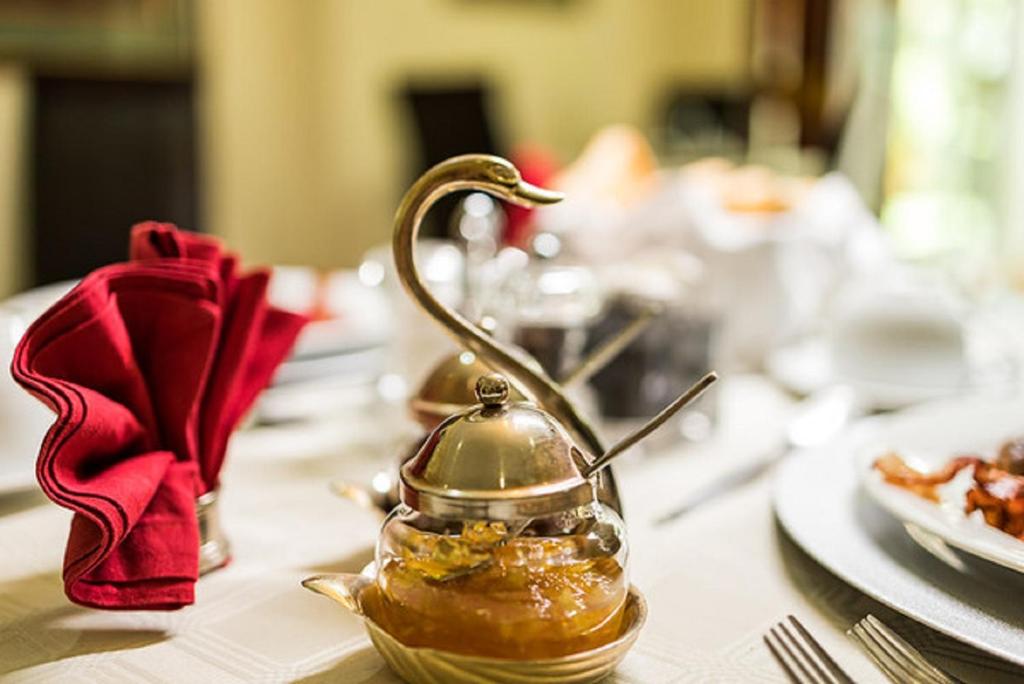 a tea kettle on a table with a plate of food at Gallo Manor Executive Bed & Breakfast in Johannesburg