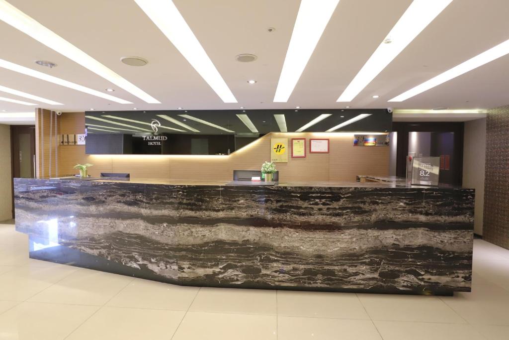 a lobby with a granite counter in a building at Talmud Hotel Yizhong in Taichung