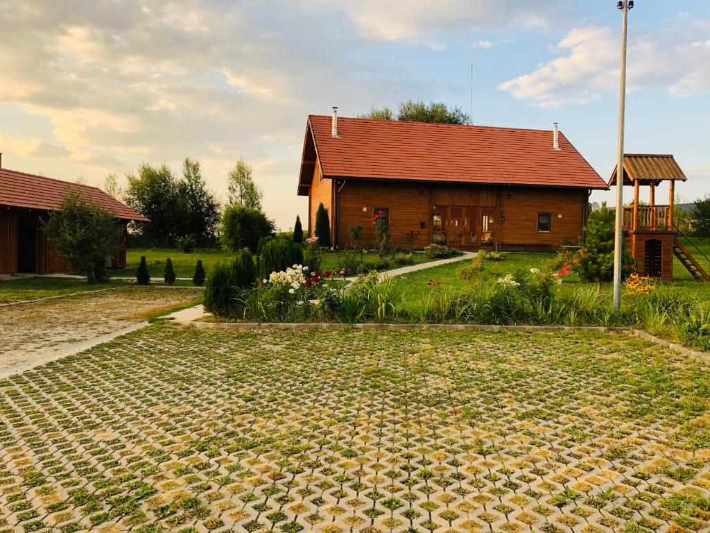 uma casa com um quintal de tijolos em frente a uma casa em Nimfa Apartments em Păuleni-Ciuc