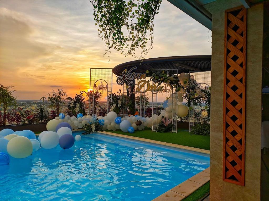 a swimming pool with white and blue balloons in a backyard at Holiday One Can Tho Hotel in Can Tho