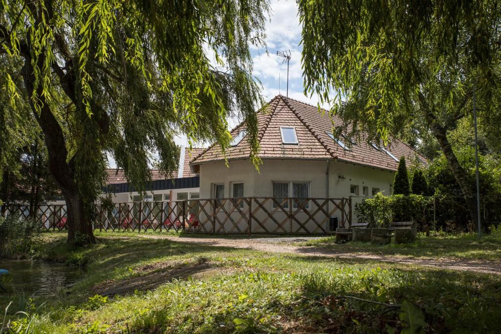 ein Haus mit einem Zaun davor in der Unterkunft Tó-Part Panzió Kőszeg in Kőszeg
