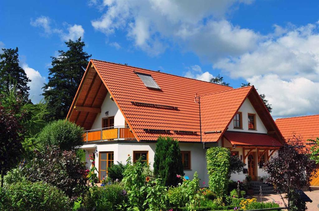 ein Haus mit orangefarbenem Dach in der Unterkunft Ferienwohnung an der Waldmühle in Reulbach
