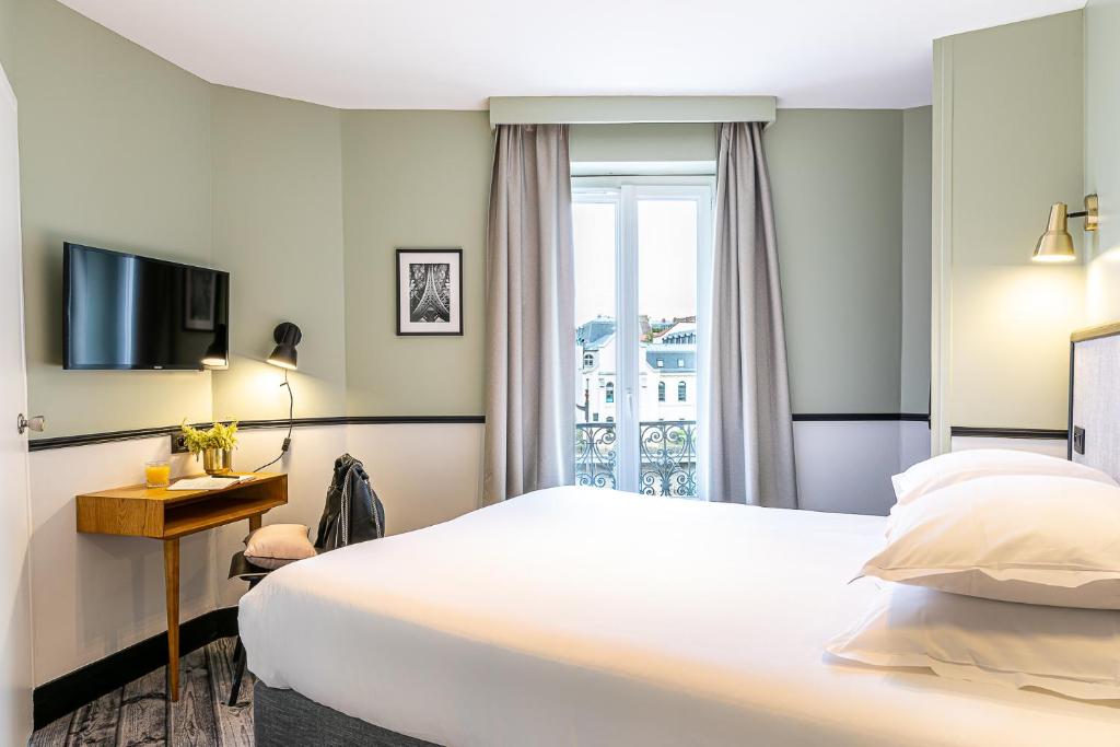 a hotel room with a bed and a television at Hotel de l'Aqueduc in Paris