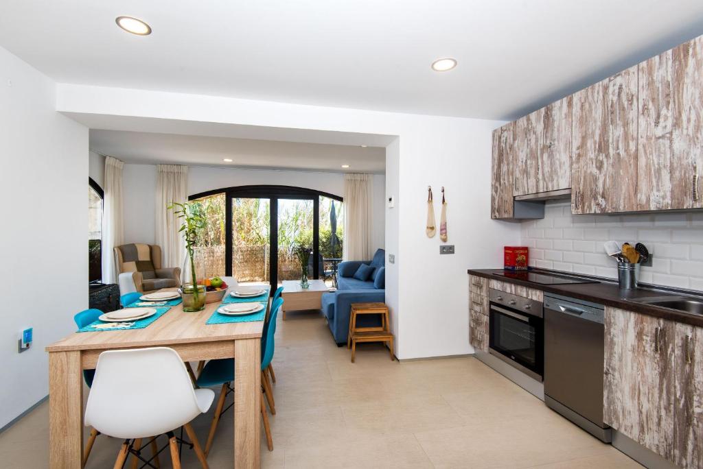 a kitchen and living room with a wooden table and chairs at Beach Pearl Cala de Mijas in Mijas
