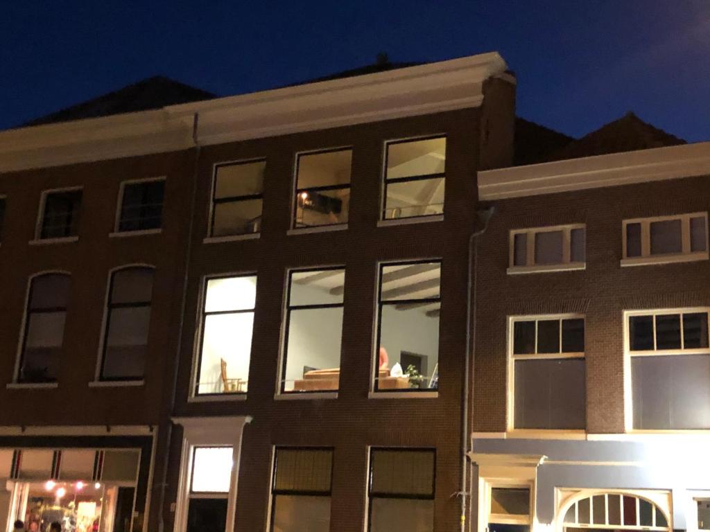 um edifício com luzes nas janelas à noite em Five Churches View apartments em Haarlem