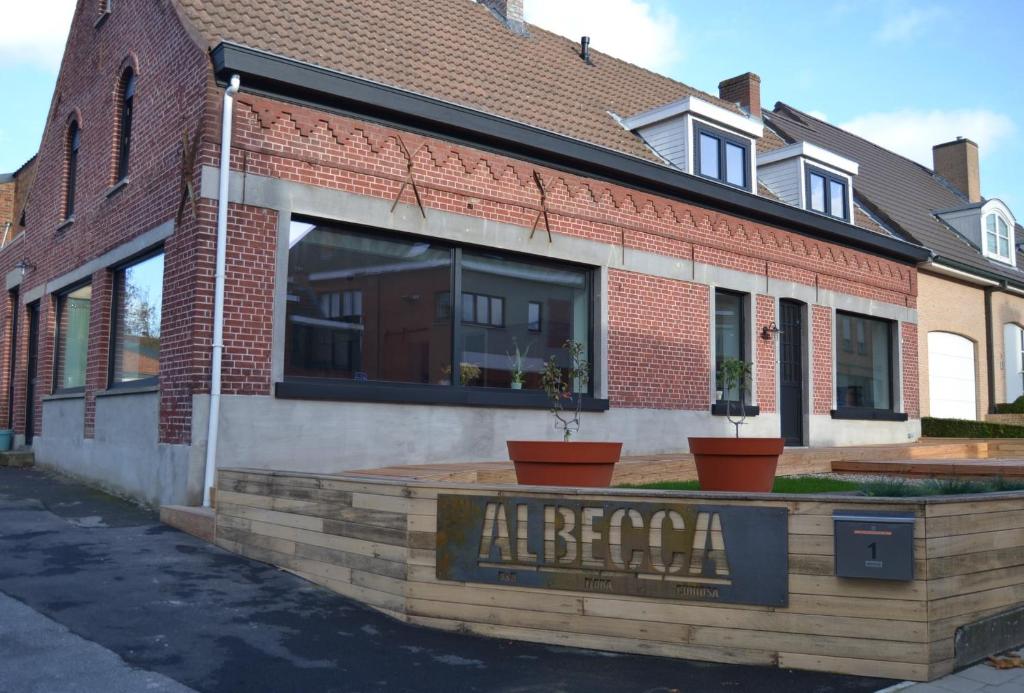 a brick building with a sign that reads all beamed at Albecca 