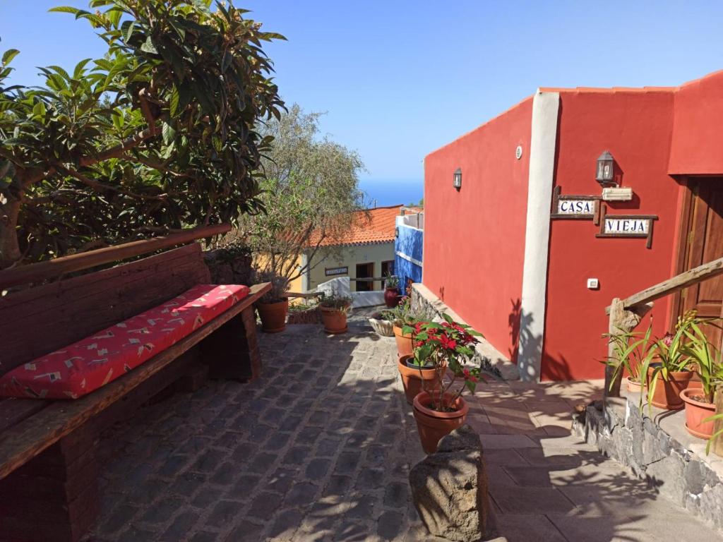 a bench on a patio with plants and a building at Casa El Comisario in Tanque