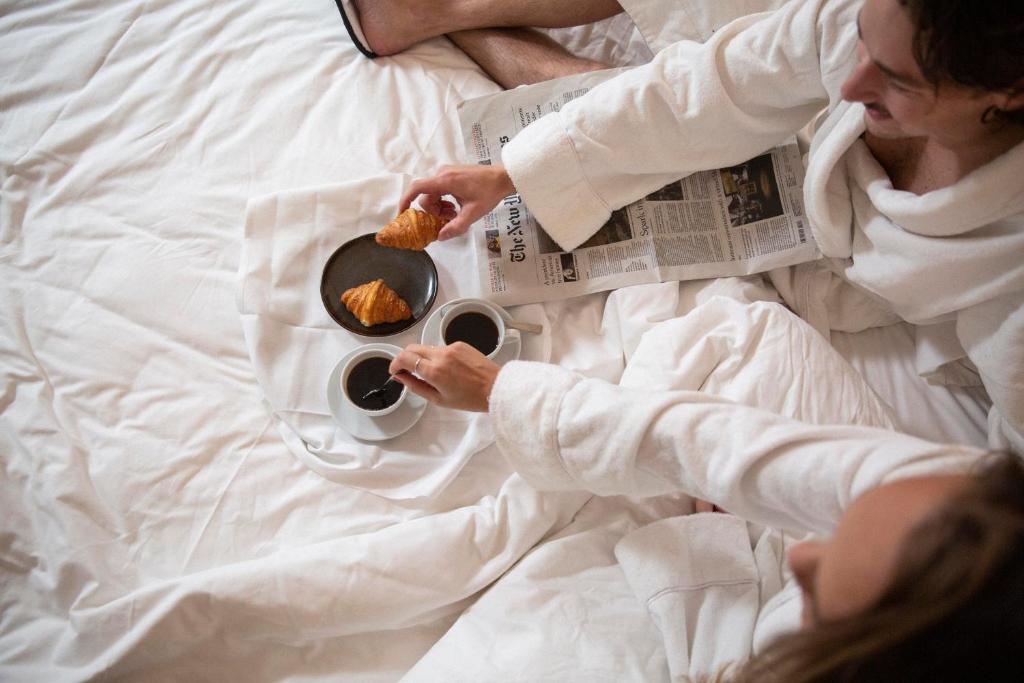 a person laying in bed reading a newspaper at Berns, Historical Boutique Hotel & House of Entertainment since 1863 in Stockholm
