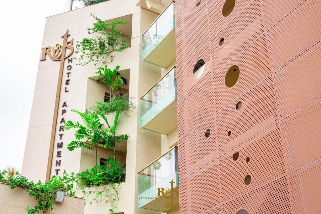 un bâtiment avec des plantes sur son côté dans l'établissement Roots Hotel Apartments Abidjan, à Abidjan