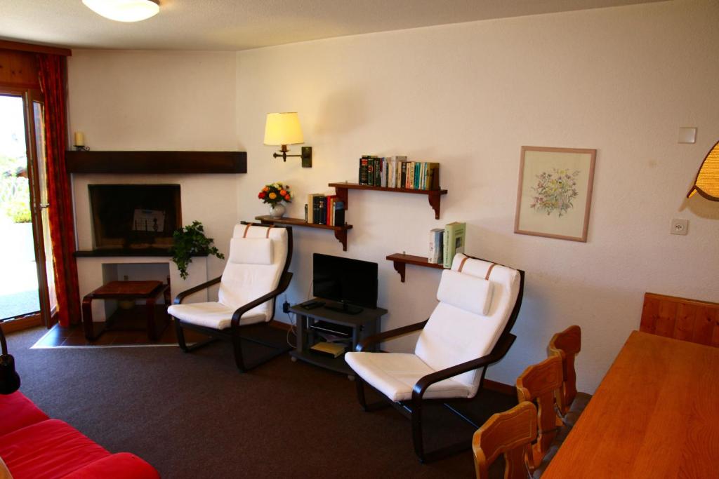 sala de estar con 3 sillas y escritorio con ordenador en Greppons COSY & MOUNTAIN apartments by Alpvision Résidences, en Veysonnaz