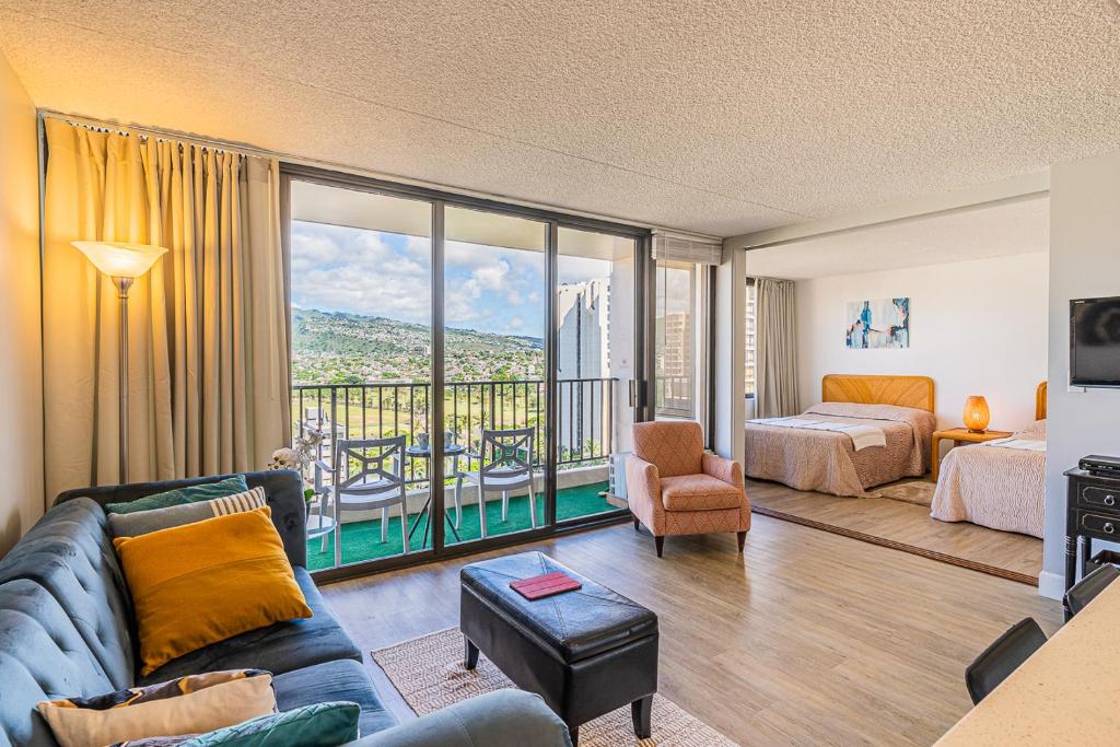 sala de estar con sofá, cama y balcón en Free Parking, Pool, Sauna, Spa, WiFi, BBQ, AC - Waikiki Banyan, en Honolulu