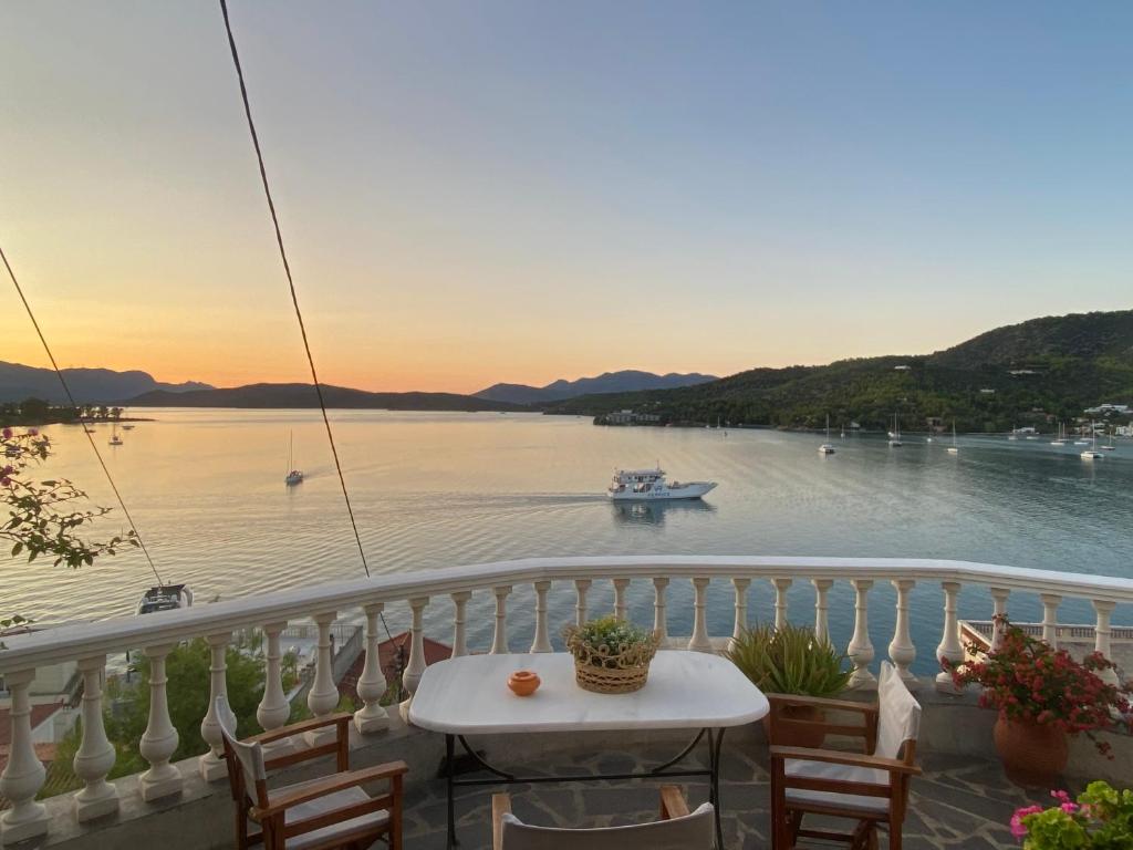 een balkon met een tafel en een boot in het water bij Kasteli Suite in Poros