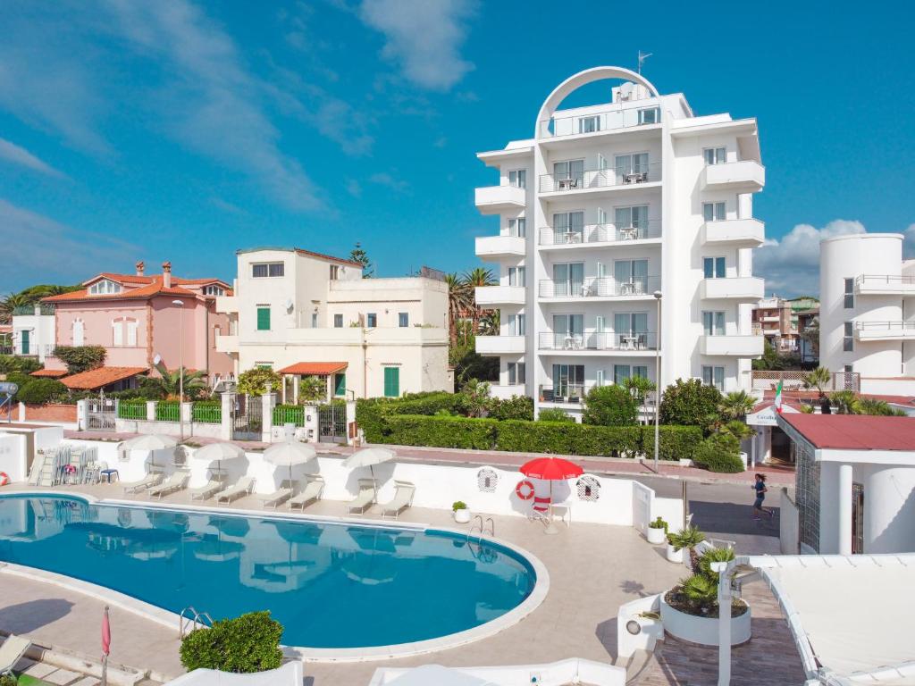 un hotel con piscina frente a un edificio en Hotel Cavalluccio Marino en Santa Marinella