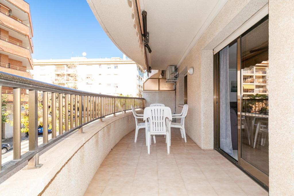 balkon z białymi krzesłami i stołem. w obiekcie UHC STELLA MARIS APARTMENTS w mieście Cambrils