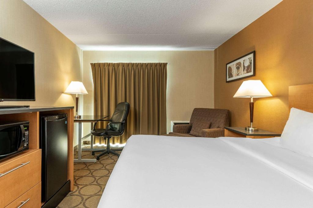 a hotel room with a bed and a television at Comfort Inn in Saguenay