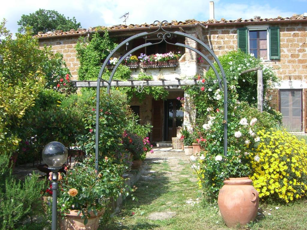 ogród z altaną i kwiatami przed budynkiem w obiekcie Le Querciolaie Monte Cavallo - entire house w mieście Saturnia