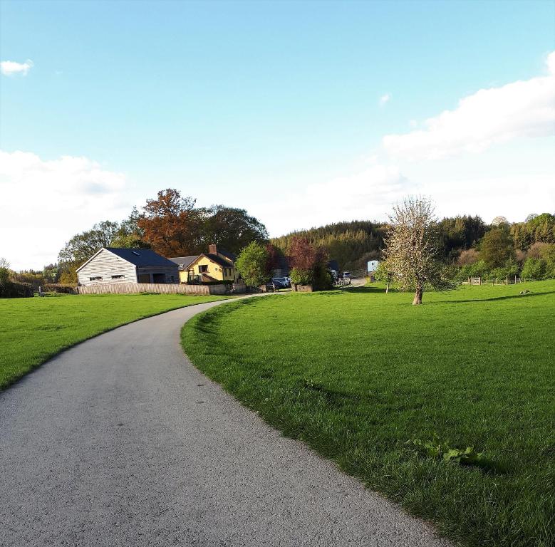 a winding road in a field with a house at Gwilym's Stable in Builth Wells