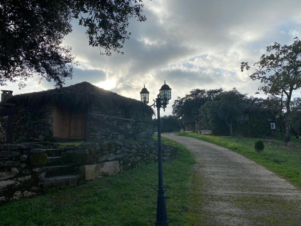 una luz de la calle frente a un edificio de piedra en complejo rural el prado, en Logrosán