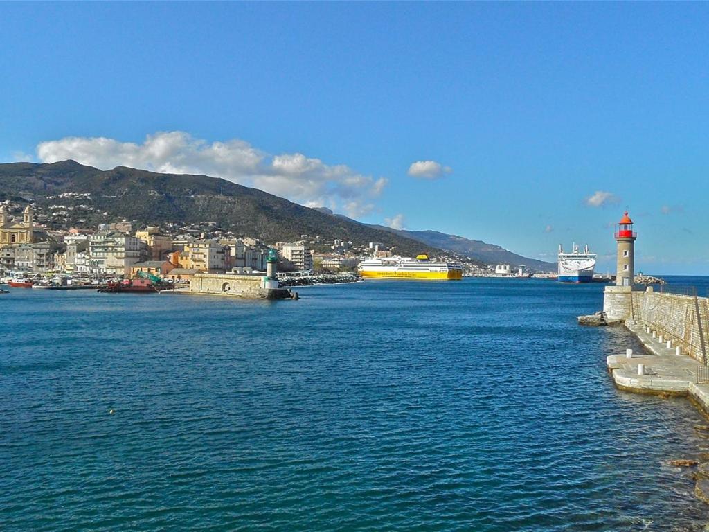 a large body of water with a lighthouse and a city at Maison d'hôtes Bastia in Bastia