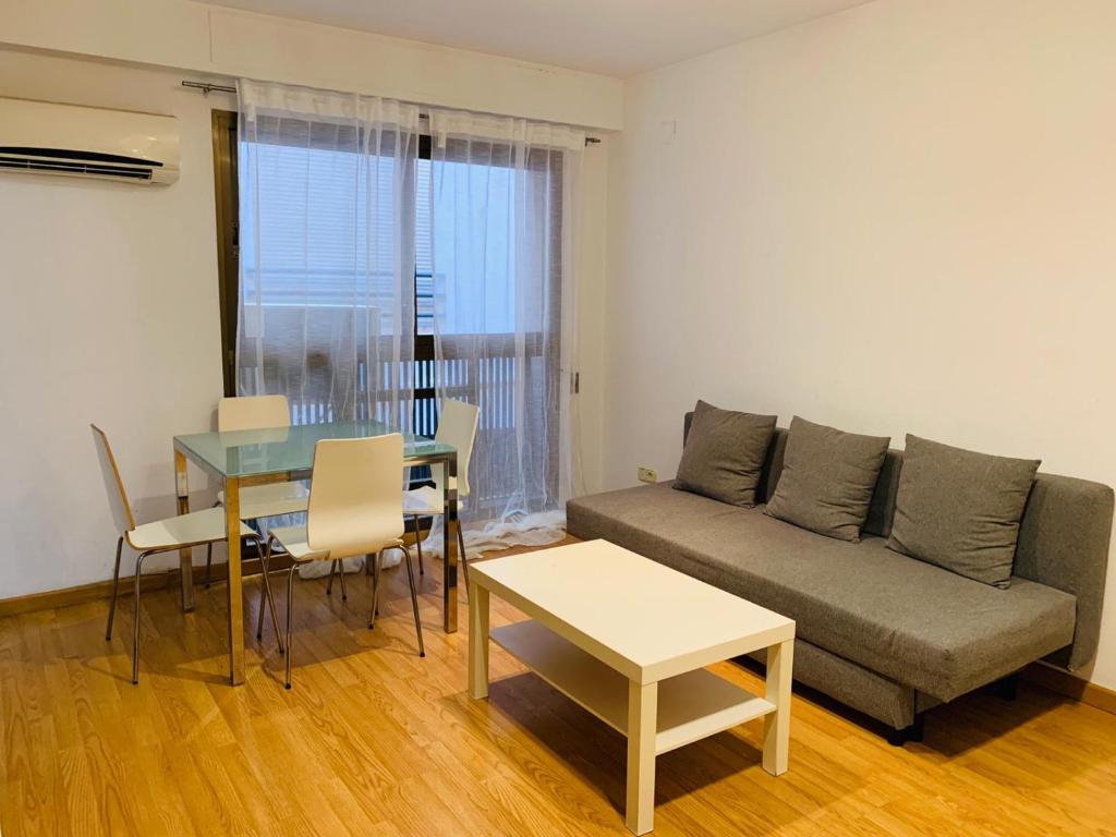 ein Wohnzimmer mit einem Sofa und einem Tisch in der Unterkunft Coroa Ayuntamiento in Valencia