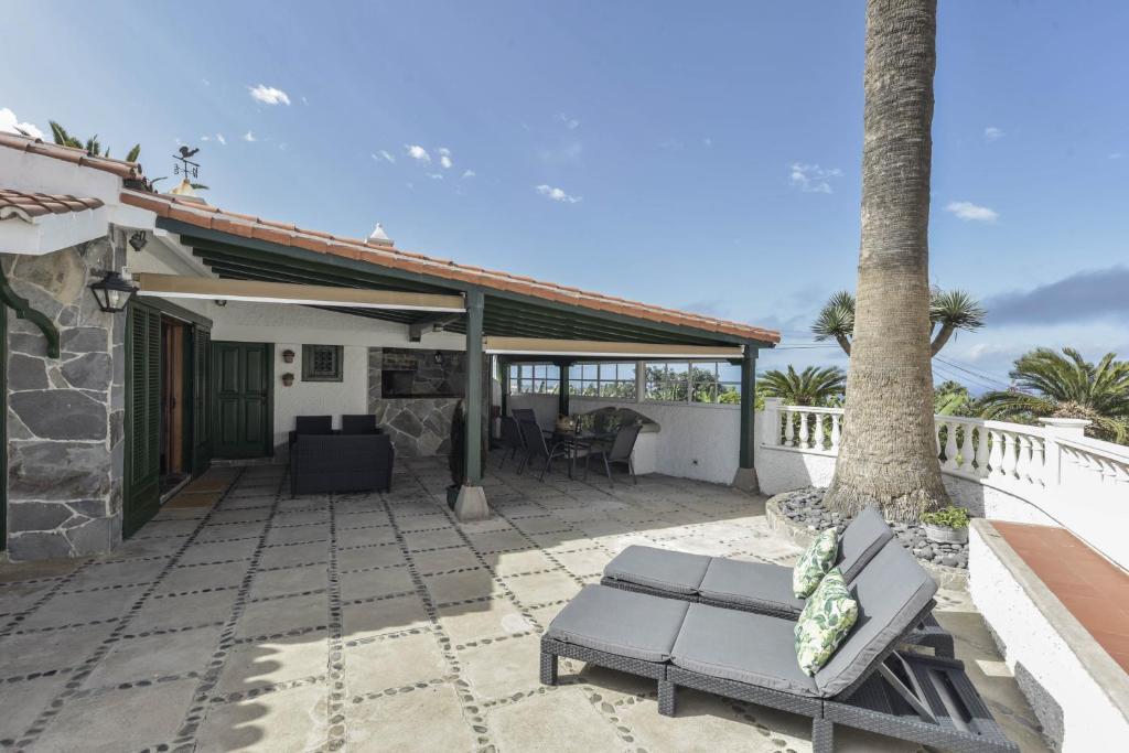 een patio van een huis met een tafel en een bank bij La Casita de Los Orovales in Puerto de la Cruz