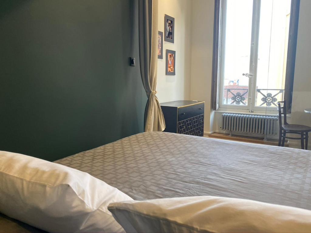 a bedroom with a large bed with a window at Appartement entier - refait à neuf - Loft - City Center in Lyon