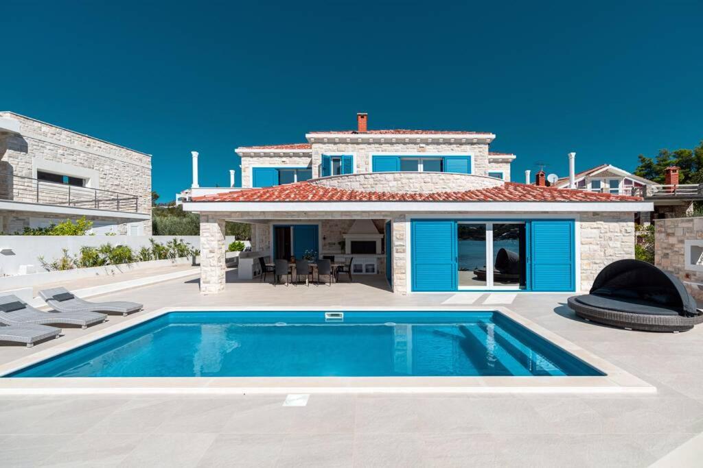 uma villa com piscina em frente a uma casa em Villa Azzurro em Vela Luka