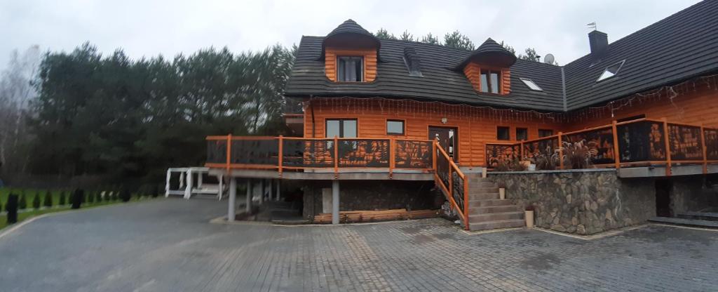 uma casa grande com um grande deque numa entrada em Agroturystyka SABAT em Imielno