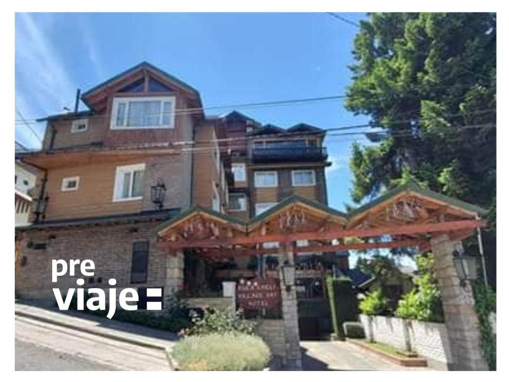 un edificio con un cartel que dice valor de pastel en Ruca Cheli Village Ski Hotel, en San Carlos de Bariloche
