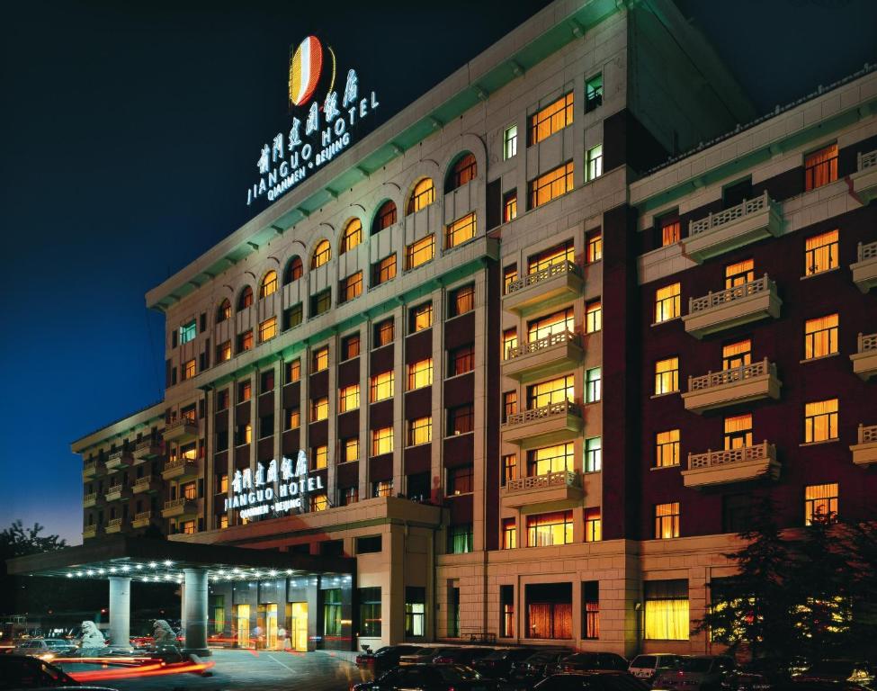 a building with a sign on top of it at night at Jianguo Qianmen Beijing in Beijing