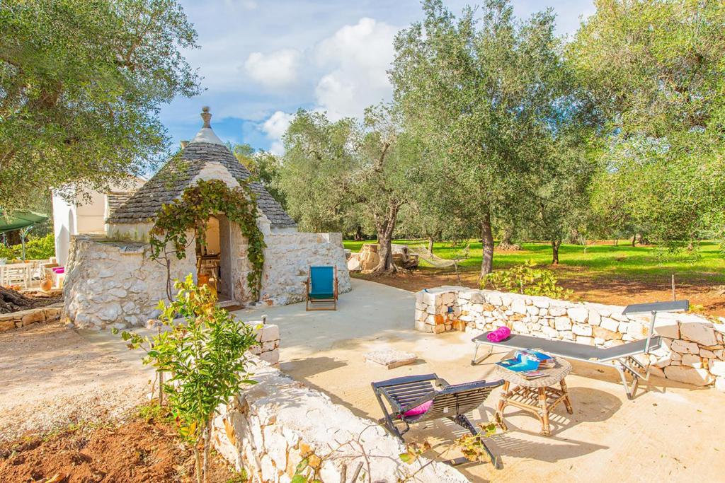 un pequeño edificio de piedra con una mesa y sillas en Il trullo della Quercia, en San Michele Salentino