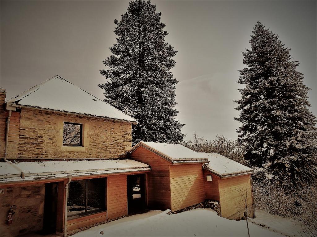 un edificio con nieve junto a dos árboles en Domaine des Marequiers le Gite Aigremoine, en Saint-Germain-du-Teil