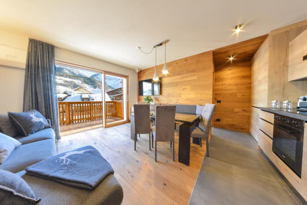 a kitchen and living room with a table and a couch at San Vigilio di Marebbe - Suite di Montagna in San Vigilio Di Marebbe