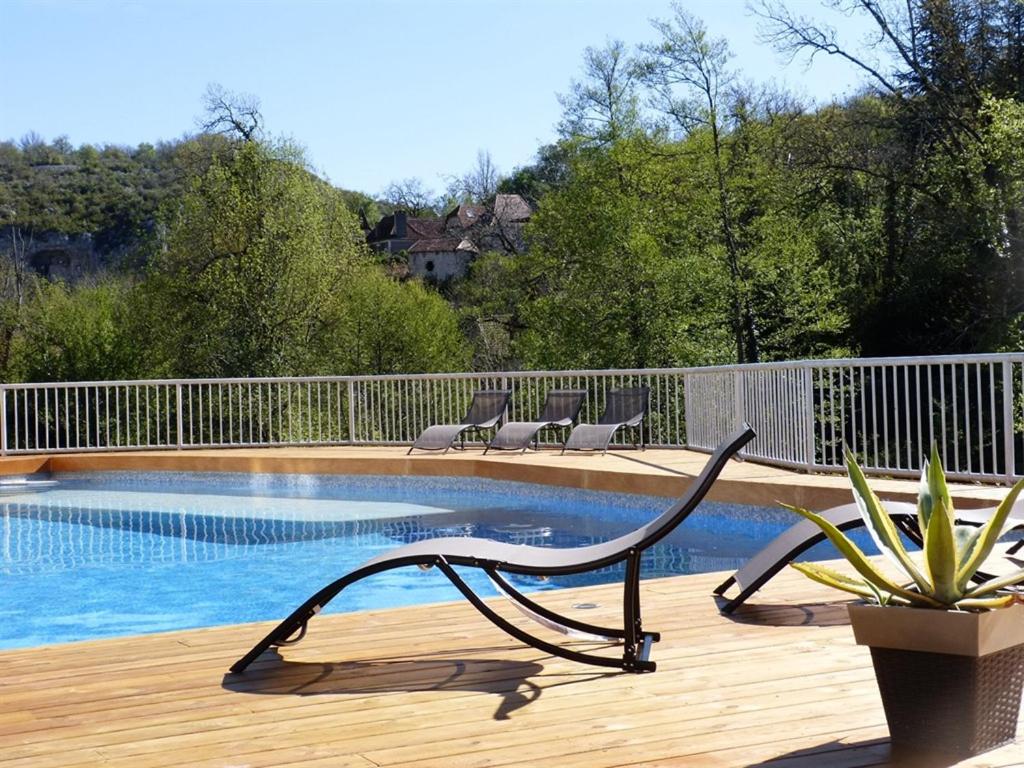 un banco sentado en una terraza junto a una piscina en Hôtel Restaurant des Grottes du Pech Merle, en Cabrerets