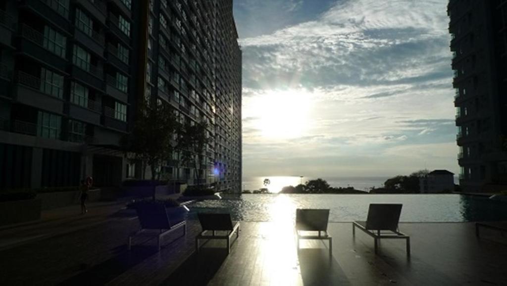 a group of chairs sitting in front of a body of water at The Relaxing Room Sea View at Lumpini Park Beach Jomtien Condominium Pattaya in Jomtien Beach