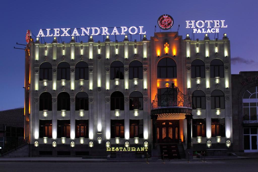 a lit up hotel building with a sign on it at Alexandrapol Palace Hotel in Gyumri