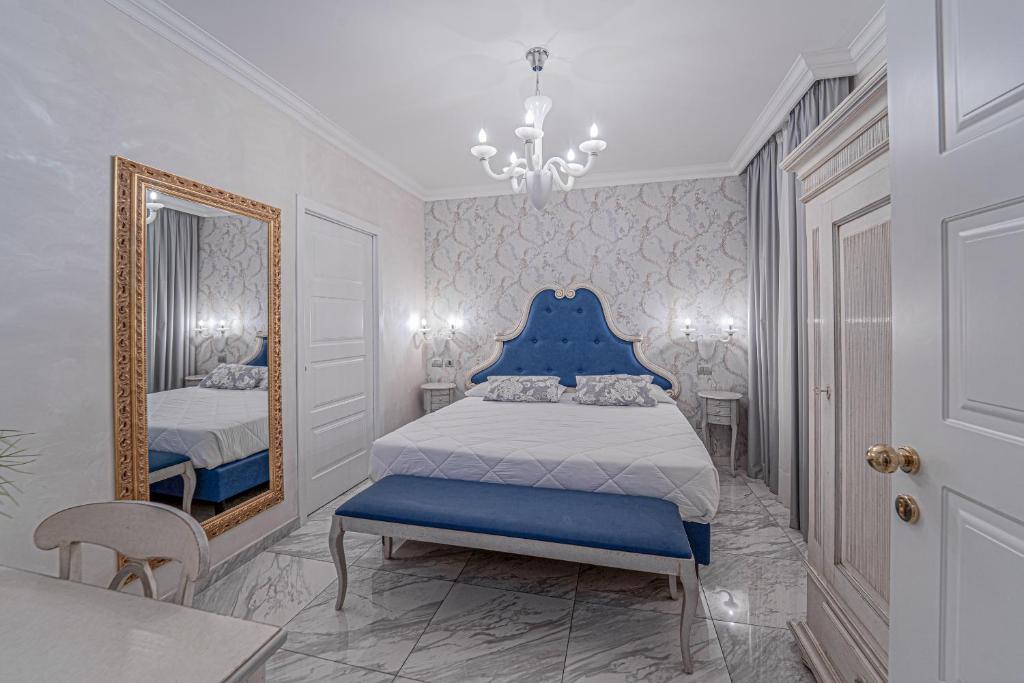 a bedroom with a blue bed and a mirror at Hotel Colomba D'Oro in Tropea